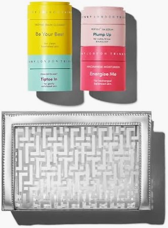 Colorful skincare jars beside silver patterned clutch