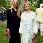 Two women in dresses smiling outdoors