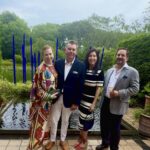 Group portrait in garden by blue sculpture pond