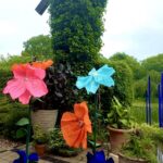 Giant colorful flowers near ivy-covered windmill