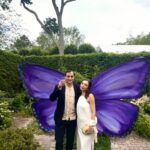 Couple posing with large purple butterfly wings