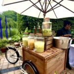 Wooden lemonade cart under white umbrella
