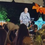 Man speaking at outdoor dinner under tent