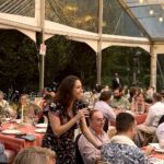 Woman speaking at tented outdoor dinner party