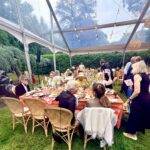 Guests at outdoor tented dinner under string lights